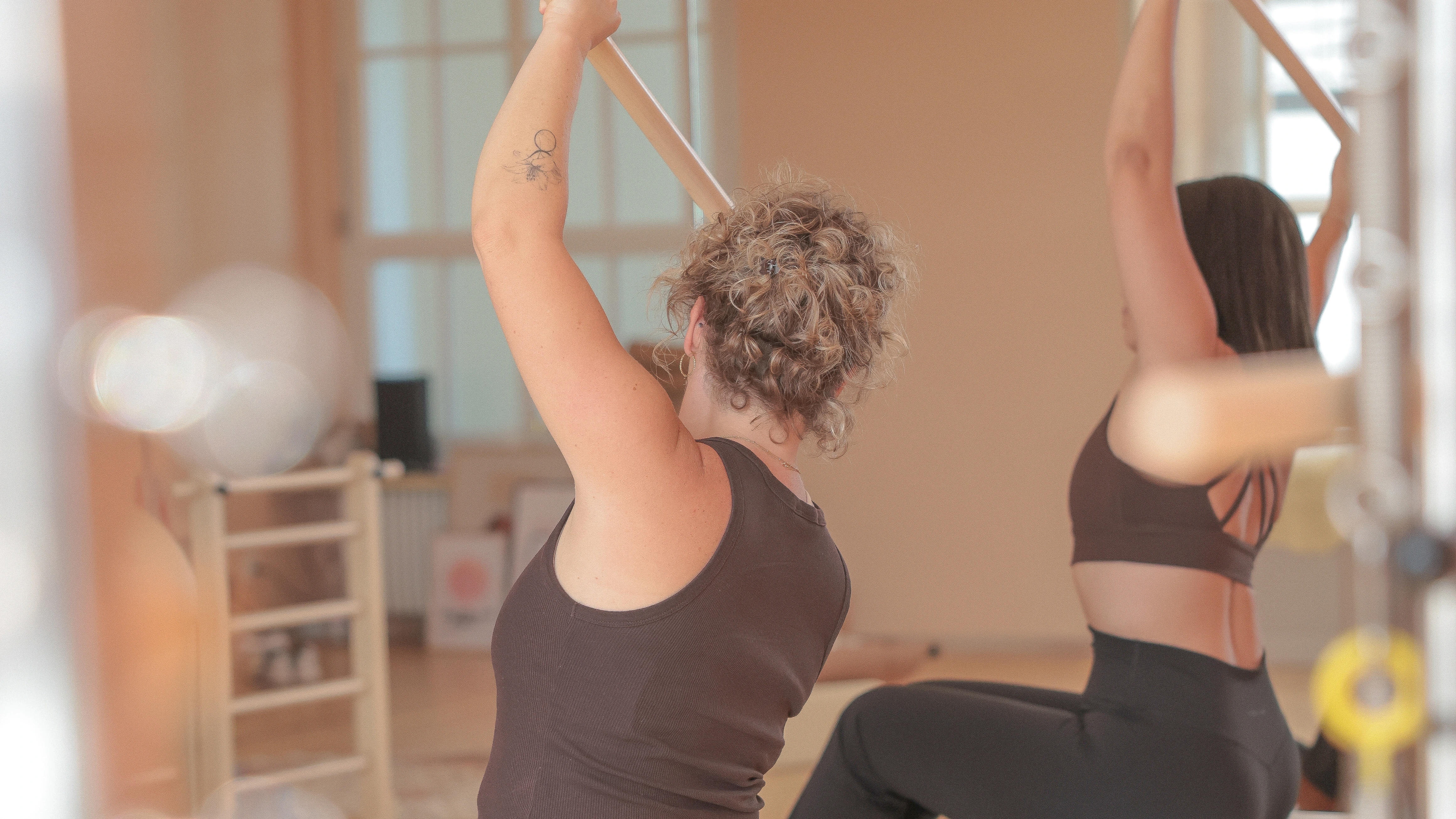 Zwei Frauen von hinten beim Training mit der Pilates-Stange im Shakti Studio